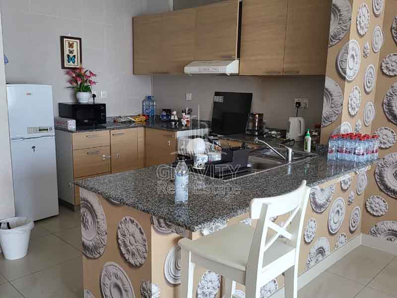 large-open-kitchen-with-light-brown-cabinets-microwave-and-oven-in-1-bedroom-apartment-in-sigma-2-tower