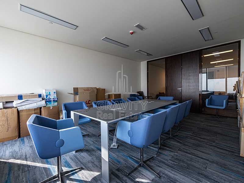 meeting-area-with-multiple-blue-chairs-and-large-black-desk-in-addax-tower-al-reem-island