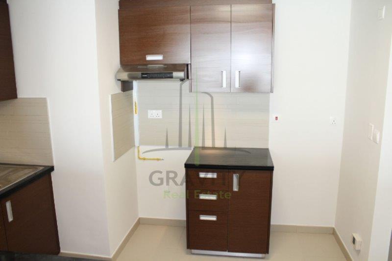 neat-kitchen-with-dark-brown-cupboards-and-cabinet-in-a-studio-apartment-for-rent-in-the-arc-tower-al-reem-island