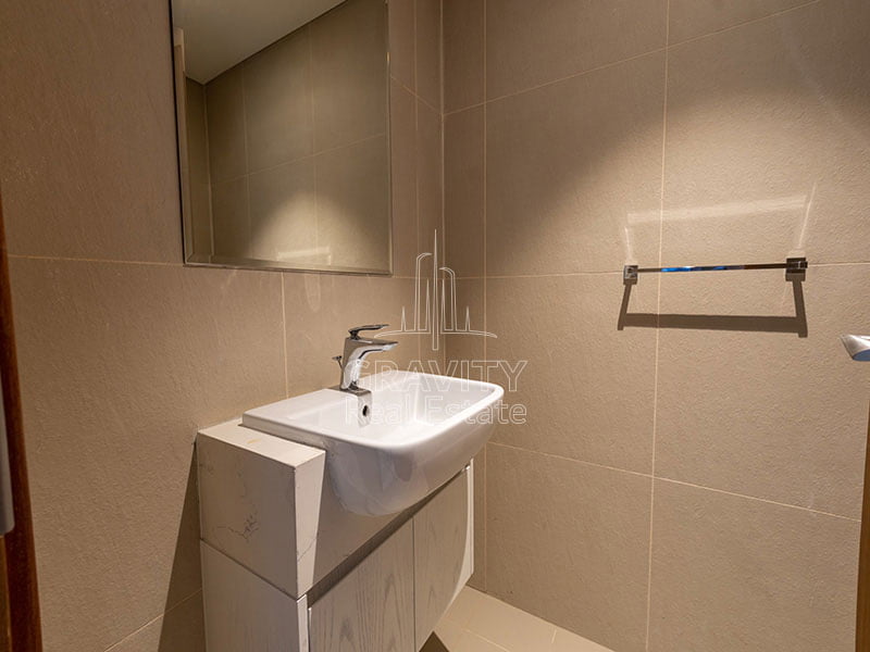 nicely-lit-bathroom-with-white-sink-and-mirror-in-1-bedroom-apartment-in-julphar-residence