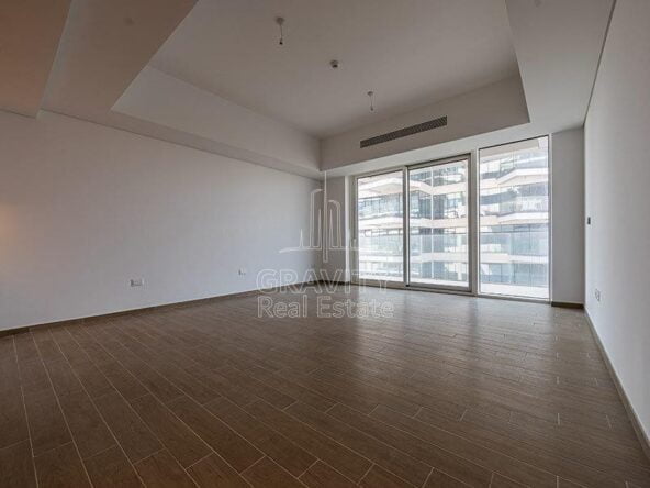 spacious-living-room-with-glass-window-facing-towards-the-view-and-entrance-to-the-nig-balcony-mayan-yas-island