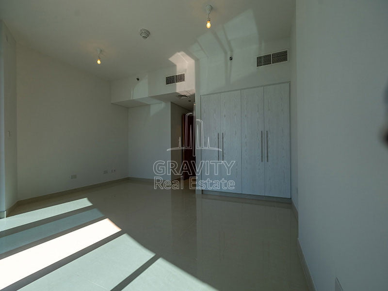 spacious-master-bedroom-with-large-white-wardrobes-and-ceramic-tiles-in-apartment-in-julphar-residence-tower