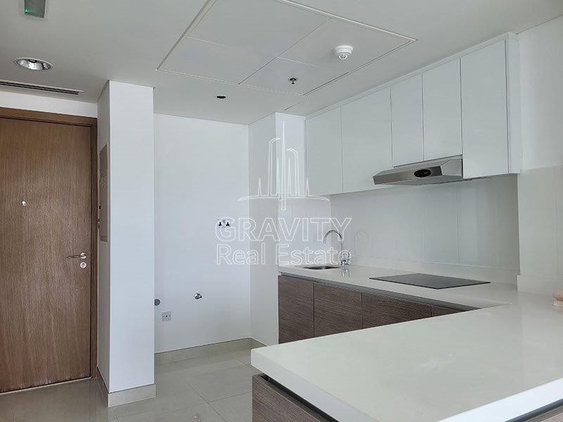 wooden-touched-and-white-marble-touched-open-kitchen-area-with-the-entrace-foor-for-the-studio-al-hadeel-raha-beach