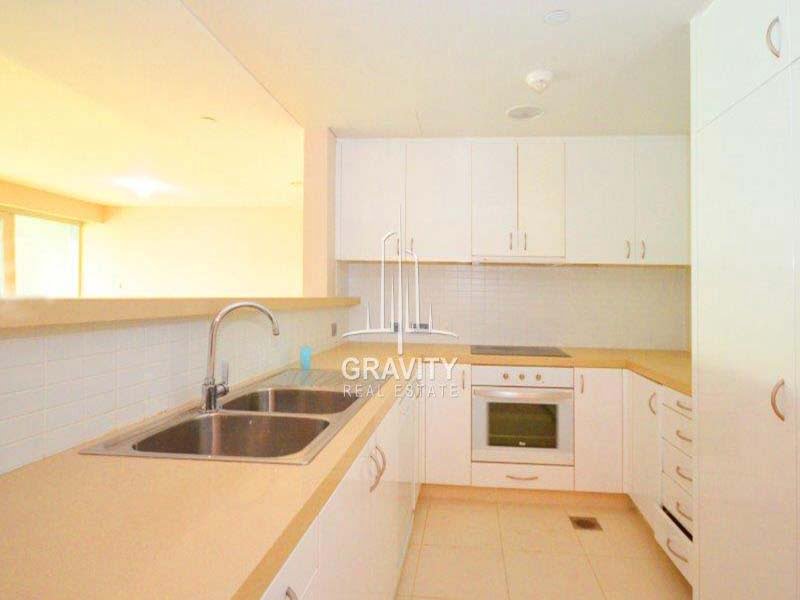 modern-fitted-kitchen-with-white-cabinets-and-cupboards-of-a-2-bedroom-apartment-in-al-maha-1-raha-beach