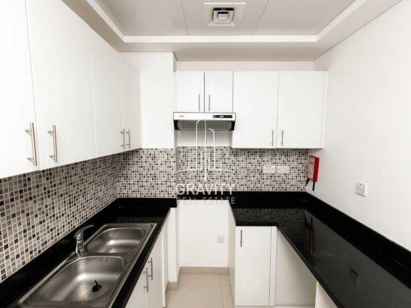 modern-kitchen-w-white-cupboards-and-cabinet-od-a-1-bedroom-apartment-in-al-ghadeer-2-for-sale