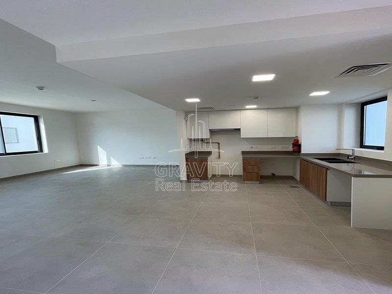 spacious-living-area-w-open-kitchen-of-a-2-bedroom-apartment-in-al-ghadeer-for-sale