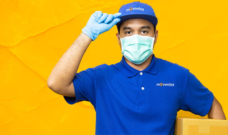 movonics-packer-in-blue-uniform-and-hat-holding-a-box-and-tipping-his-hat