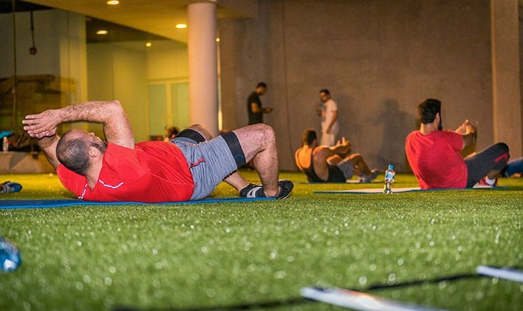 primal-gym-reem-island-group-doing-out-door-exercises-on-grass