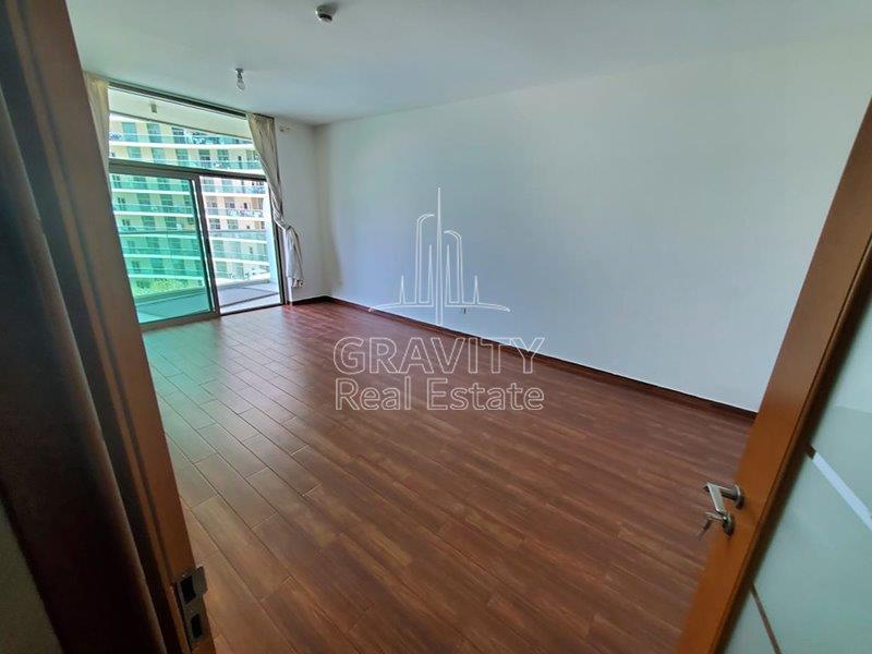 spacious-living-area-w-glass-door-to-balcony-wooden-floor-of-a-1-bedroom-in-beach-tower-apartments-reem-island