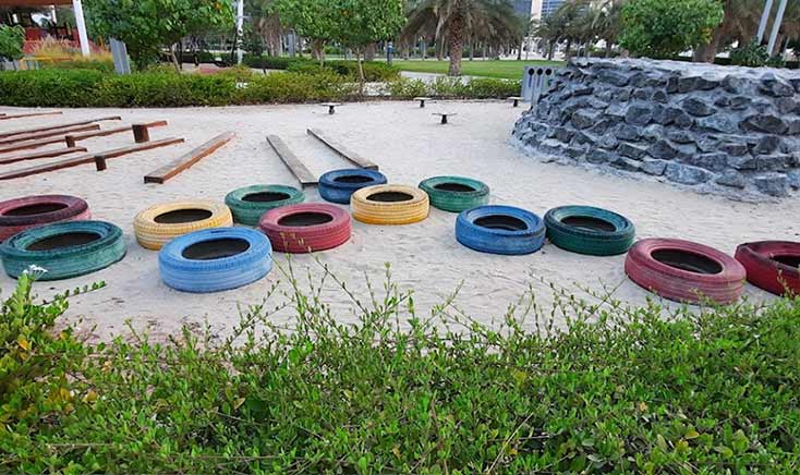 colorful-play-tires-on-sand-in-gateway-park