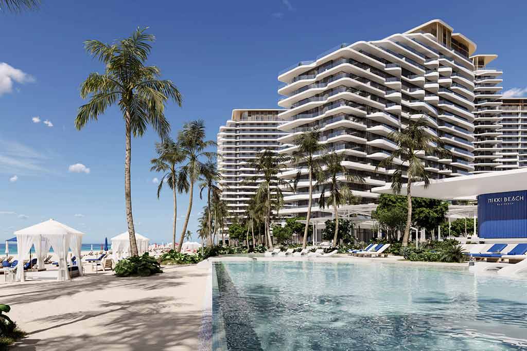 outdoor pool area surrounded by palm trees of Nikki Beach residences Al Marjan