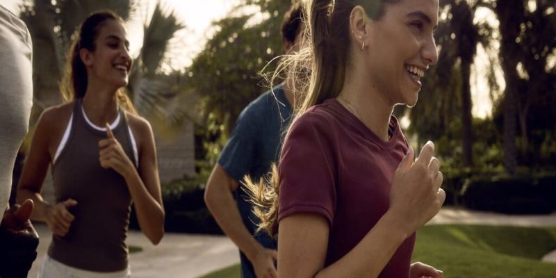 group of people running in the park in the athlon by aldar community